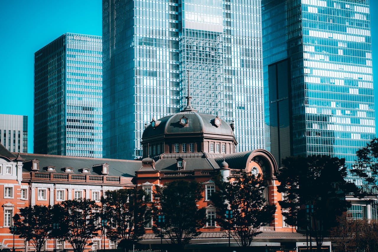 Services-02 Urban scene of modern skyscrapers and historic Tokyo Station in vibrant morning light.